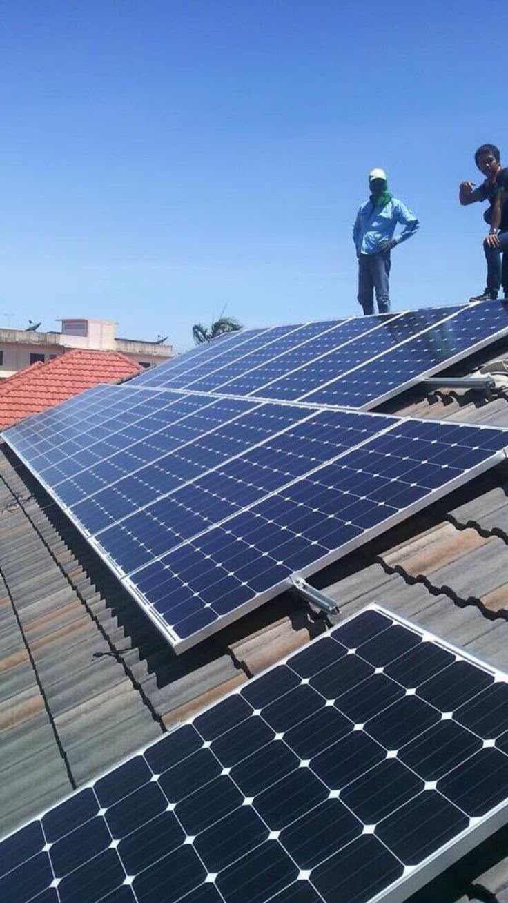 Equipa técnica a instalar painéis solares no telhado
